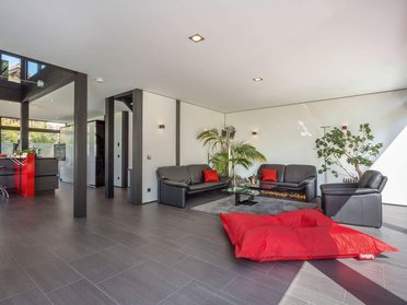 Helles Wohnzimmer in einem Architektenhaus mit roten Akzenten