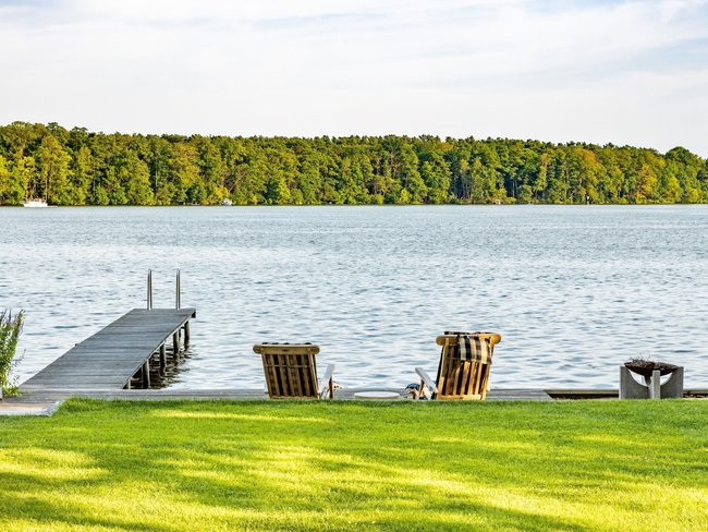 HUF Haus am Wasser mit Stuhl-Ensemble und Holzsteg