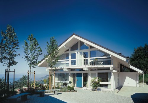 Helles Haus mit großen Fenstern und umgebendem Garten