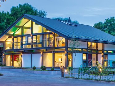 Elegantes modernes Haus mit großen Fenstern und grüner Umgebung