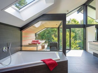 Helles Badezimmer mit Fenster, Badewanne und modernen Designelementen