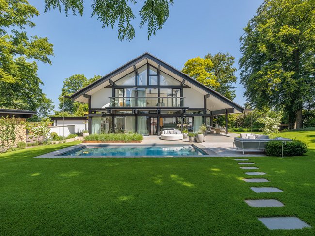 Architektenhaus mit Garten und Pool, zeitloses Design.