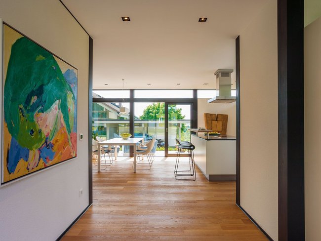Helles Interieur mit Holzfußboden und großem Fenster im Essbereich