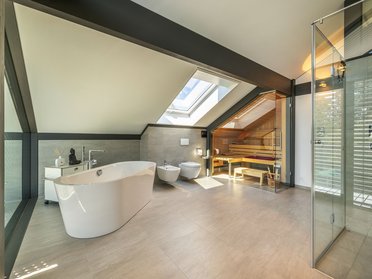 Helles Badezimmer mit freistehender Badewanne und Fenster