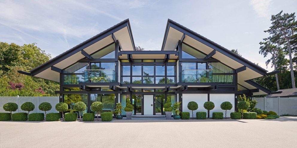 Modernes Architekturrhaus mit großen Fenstern und Garten