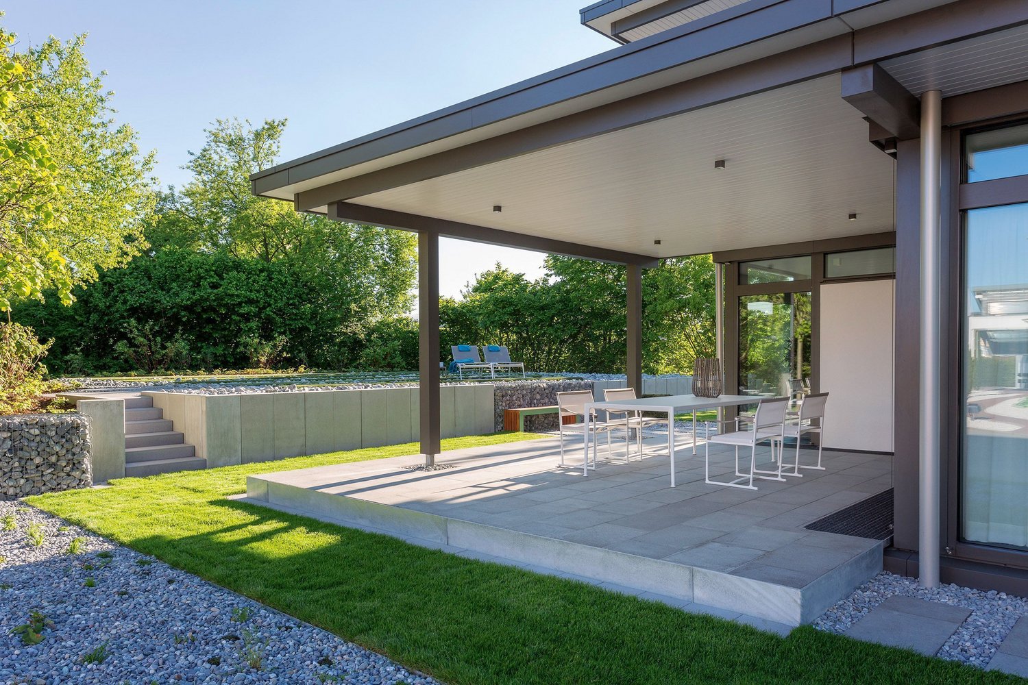 Einblick in eine moderne Terrasse mit Tisch und Stühlen im Freien