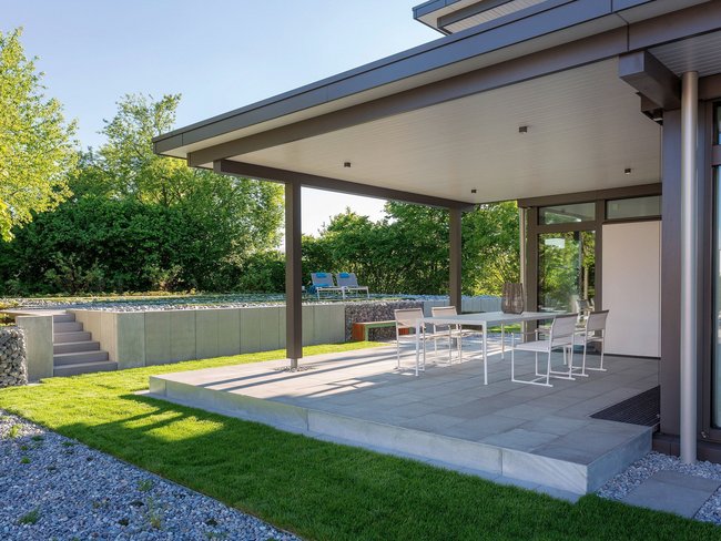 Einblick in eine moderne Terrasse mit Tisch und Stühlen im Freien