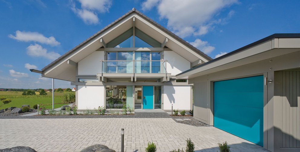Helles Haus mit blauen Akzenten und natürlicher Umgebung