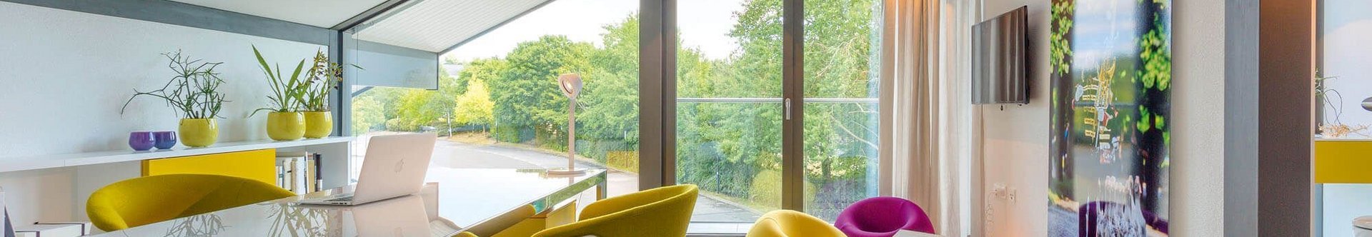 Moderne Wohnlandschaft mit bunten Möbeln Helles und luftiges Design mit gelben und lila Möbeln in einem Raum