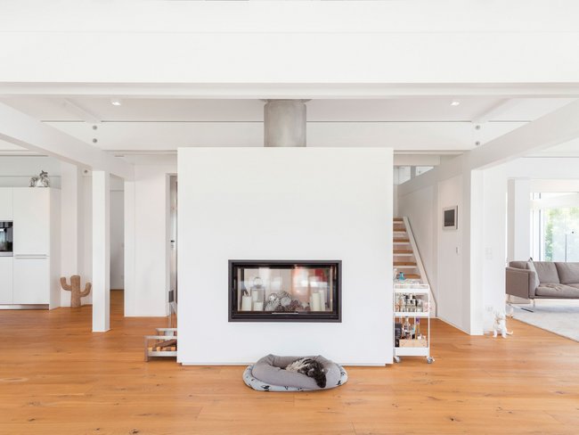 Helles Interieur mit zentralem Kamin und Holzfußboden