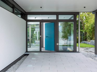 Moderne Eingangstür in einem minimalistischen Haus Eingangsbereich mit blauer Tür und ruhiger Umgebung