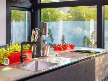 Helle Küche mit Fensterblick, frischen Zutaten und stilvollem Design