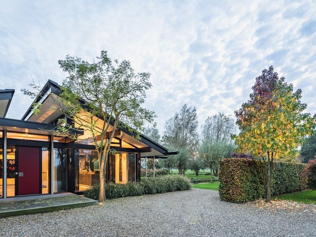 Bungalow eingebettet in eine traumhafte Landschaft mit Bäumen und Wiesen