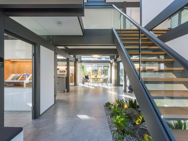 Modernes Innenarchitektur-Design mit Treppe Helles Interieur mit offener Treppe und Gartenelementen