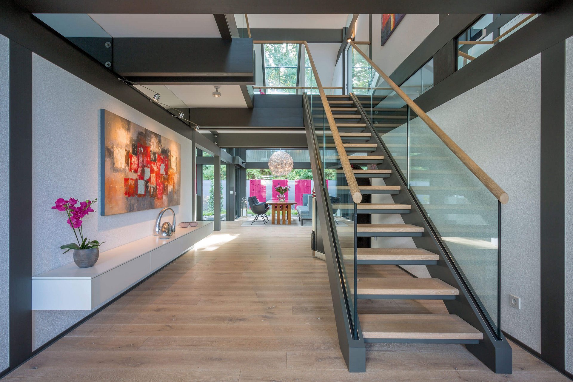 Heller Eingangsbereich mit Treppe und moderner Kunst an der Wand