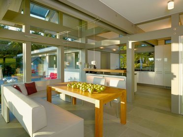 Moderne Küche im HUF HAUS mit eleganter Ausstattung Helle und großzügige Küche in einem HUF HAUS mit einer Holzdecke und einer Tischfläche mit Äpfeln.