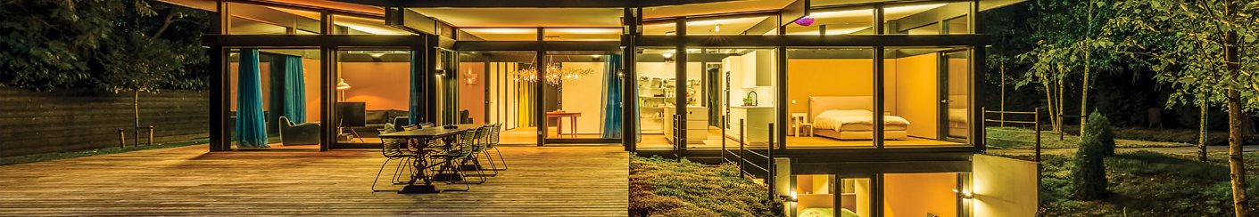 Moderne HUF Bungalow bei Nacht mit Beleuchtung Traumhaftes modernes Haus mit großen Fenstern und Terrasse