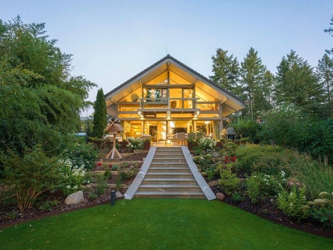 HUF Haus mit Anbau, Poolhaus und Garagenanlage Modernes Haus mit Garten, Poolhaus und Garagen, umgeben von Bäumen