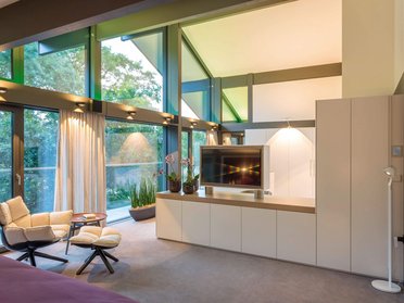 Helles Schlafzimmer mit eleganter Einrichtung und Blick auf die Natur