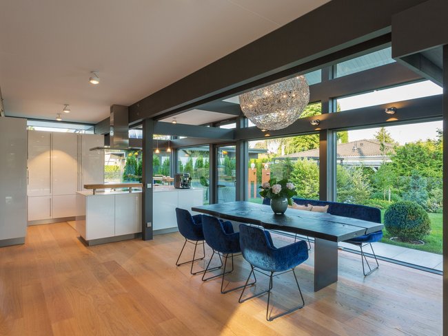 Innenansicht eines modernen Hauses mit Essbereich und Gartenblick