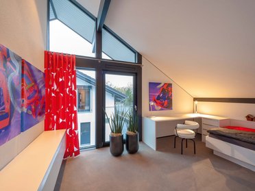 HUF Haus modum 810 Musterhaus Wuppertal 7 Gemütliches Zimmer mit großen Fenstern, modernen Möbeln und Kunstwerken