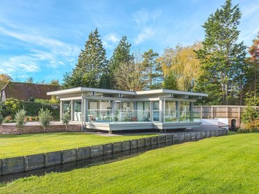 Stilvoller HUF Anbau harmonisch integriert Moderner HUF Anbau mit Glasfront und grünem Umfeld