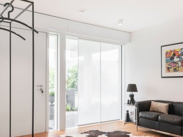 Geräumiger Raum mit schwarzem Sofa und Cowhide-Teppich