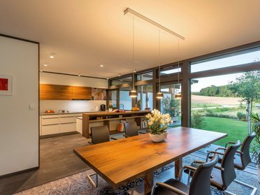 Innenansicht eines modernen Fachwerkhauses mit Essbereich und Gartenblick
