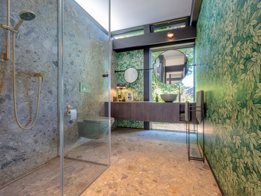 Stilvolles Badezimmer mit Naturstein, Glas und botanischem Design