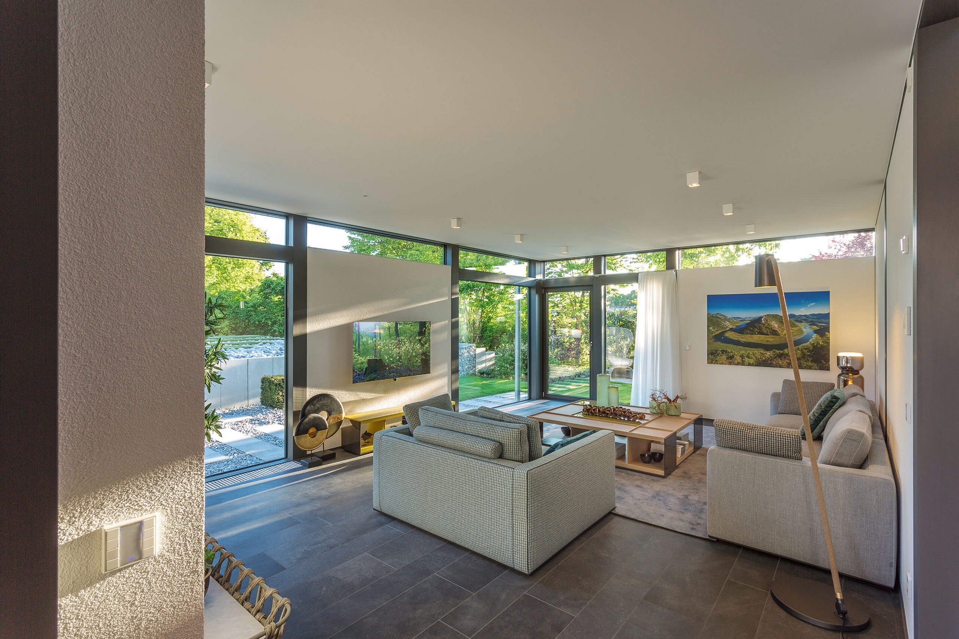 Helles Wohnzimmer mit modernen Möbeln, Blick ins Grüne
