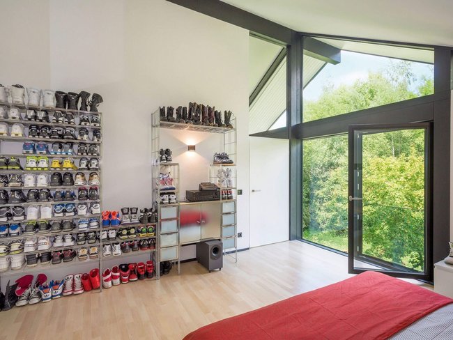 Stylisches Schlafzimmer mit Schuhregal und Aussicht ins Grüne