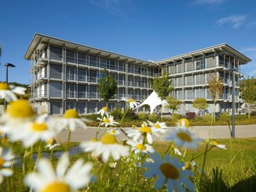 Modernes Bürogebäude HUF mit Blumen im Vordergrund