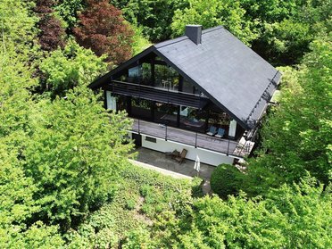 Moderne Hütte umgeben von üppigem Grün Gemütliches Haus inmitten von Bäumen und Pflanzen