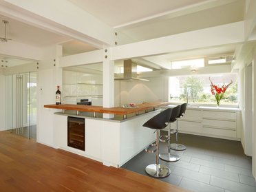 Moderne Küche in einem HUF HAUS ART 4 Offene Küche mit Holzinsel und modernen Stühlen in einem Fachwerkhaus