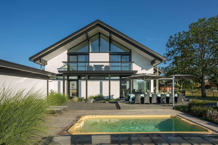 Moderne Architektur mit Pool und Terrasse Ein modernes Haus mit Glasfront, Terrasse und Schwimmbecken