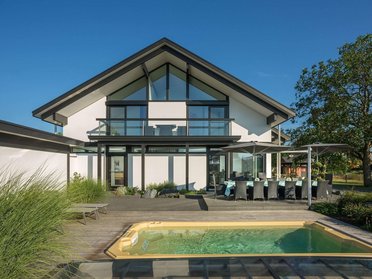 Moderne Architektur mit Pool und Terrasse Ein modernes Haus mit Glasfront, Terrasse und Schwimmbecken