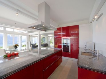 Moderner Küchenbereich in einem eleganten HUF Haus Helle und stilvolle Küche mit roten Schränken und modernen Geräten