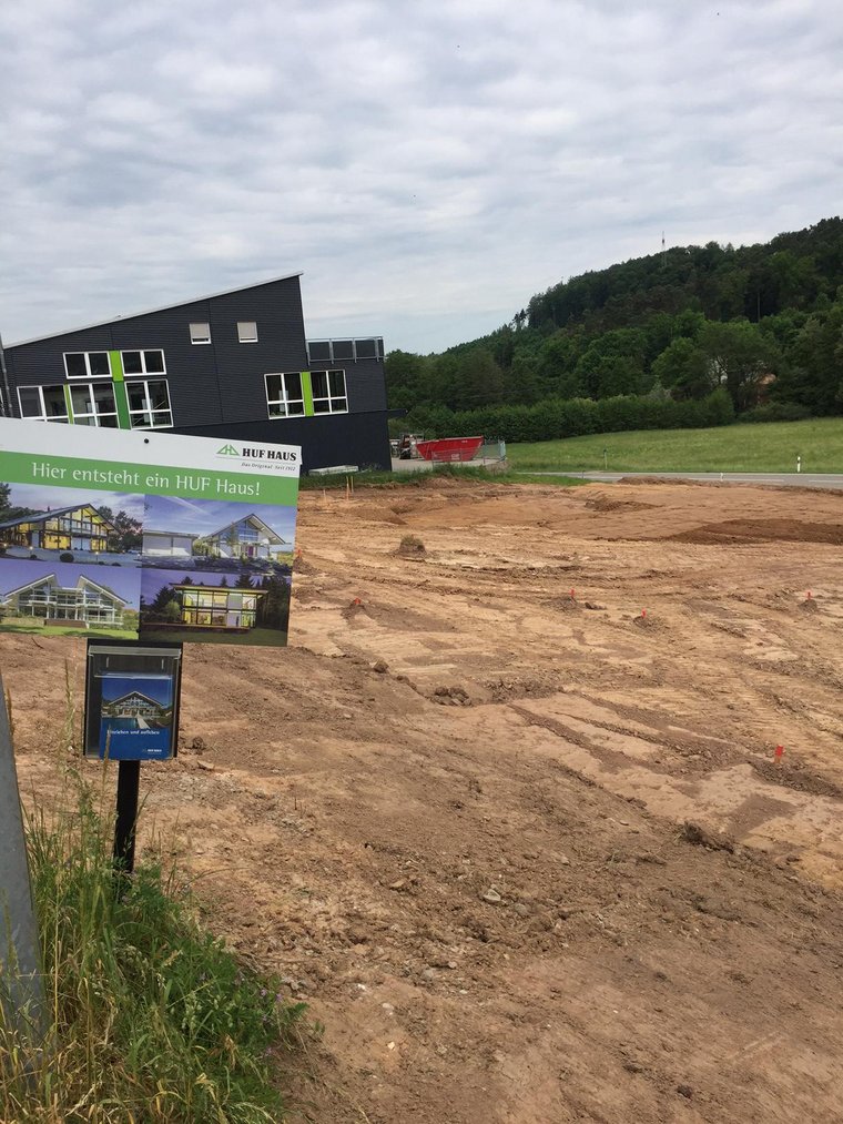 Neues Bauprojekt für ein HUF Haus Baugelände mit Hinweisschild für ein HUF Haus.