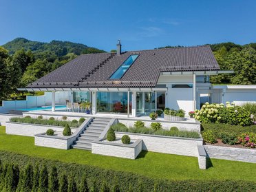 Haus mit Terrassengarten und Blick auf Hügel und See