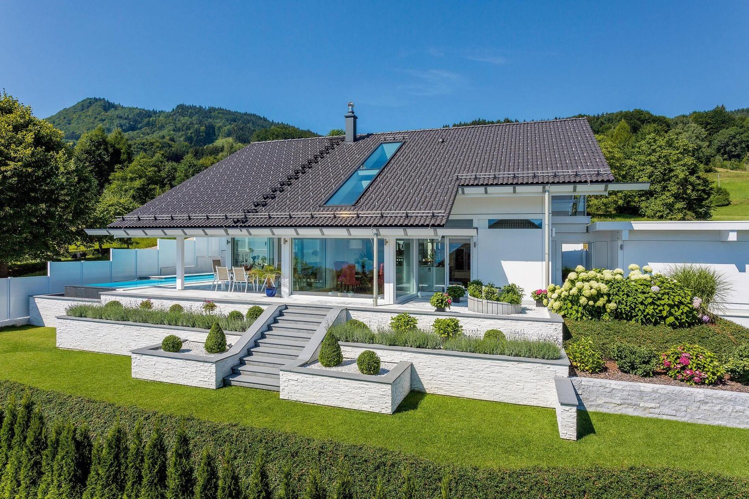 Haus mit Terrassengarten und Blick auf Hügel und See