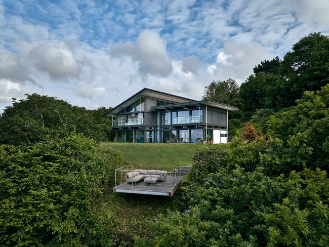 HUF Haus am Meer – modernes Designhaus Ein modernes Designhaus am Meer mit großflächigen Fenstern und Garten.