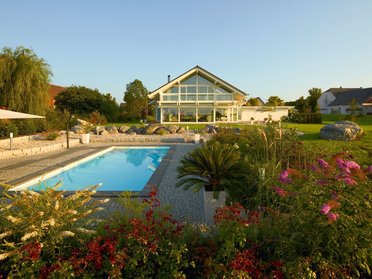 Fachwerkhaus HUF HAUS ART 4 mit Pool Modernes HUF HAUS ART 4 mit Pool und Gartenlandschaft