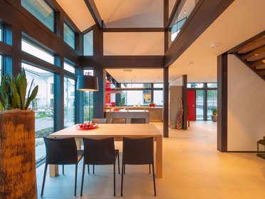 HUF Haus modum 810 Musterhaus Wuppertal 10 Hell erleuchteter moderner Wohnbereich mit Esstisch und Pflanzen