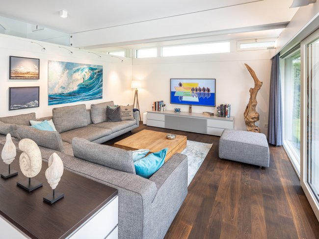 Heller Wohnraum mit gemütlicher Sofa-Landschaft und Kunstwerken