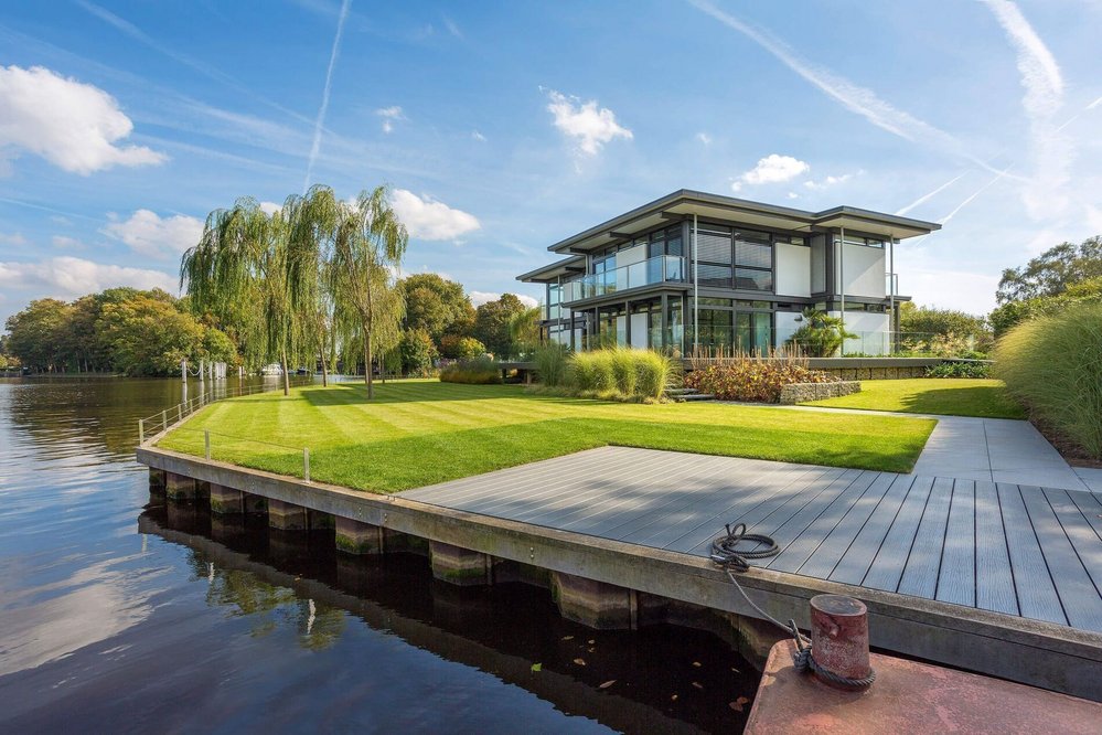 Luxushaus am Wasser mit Flachdach und Garten Moderne Architektur mit Flachdach und großzügigem Garten am See