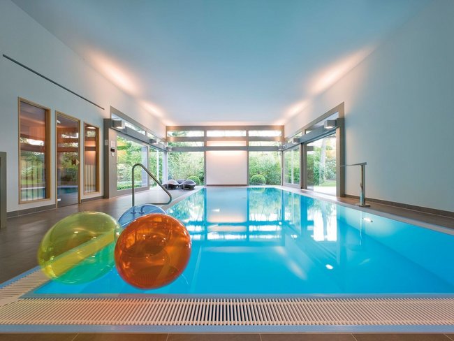 Modernes Flachdachhaus mit Swimmingpool Innenansicht eines modernen Schwimmbereichs mit bunten Wasserbällen