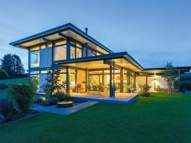 Ein modernes Fachwerkhaus mit stilvollem Design und beleuchtetem Garten