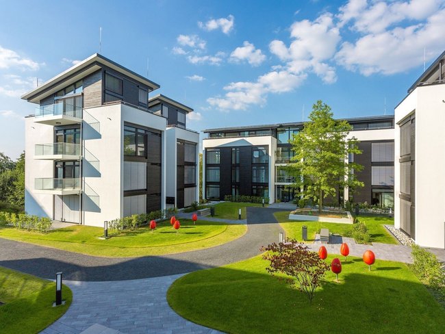 Moderne Architektur mit grüner Umgebung und Skulpturen