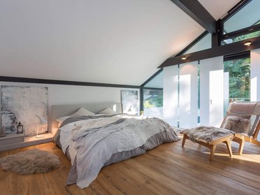 Gemütliches Schlafzimmer mit modernem Interieur und Holzfußboden