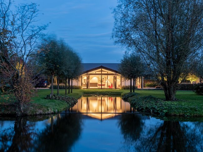Modernes Bungalow in idyllischer Landschaft mit Wasserwegen Bungalow mit organischen Formen, großen Glasflächen und schöner Umgebung